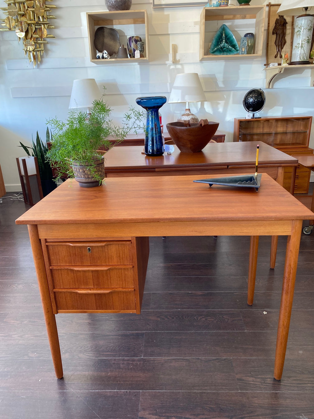 Lovely Mid-century Danish desk in teak and birch manufactured by Ejsing Møbelfabrik. Beautiful at any angle with a finished back. Three dovetailed drawers with sculpted handles. Tapered legs. The perfect fit for small spaces. Key not available. Made in Denmark- Cook Street Vintage.
