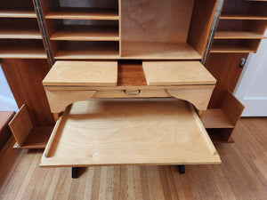 Pull put drawer of multifunctional teak folding desk designed by Swiss architects Ernst Mummenthaler and Otto Meier to resemble a cabinet. This midcentury piece opens to reveal numerous adjustable shelves and a drawer that pulls out to create the perfect work surface for your laptop or for writing. A retractable reading lamp automatically turn son when you pull it out.Recently restored, it comes with a set of keys to lock the unit once closed.- Cook Street Vintage