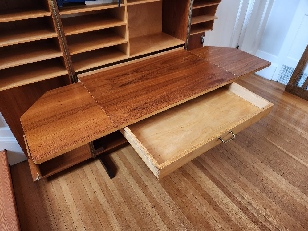 multifunctional teak folding desk designed by Swiss architects Ernst Mummenthaler and Otto Meier to resemble a cabinet. This midcentury piece opens to reveal numerous adjustable shelves and a drawer that pulls out to create the perfect work surface for your laptop or for writing. A retractable reading lamp automatically turn son when you pull it out.&nbsp; &nbsp;Recently restored, it comes with a set of keys to lock the unit once closed.- Cook Street Vintage