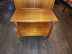 Absolutely fabulous 1960s extending teak tea cart with flared edge. Extend the two level cart to a longer serving cart by sliding the top shelf over and clicking the bottom shelf into place beside it. Original casters. Attributed to Danish furniture maker Poul Hundevad. Marked PH 28 3 on bottom shelf.- Cook Street Vintage