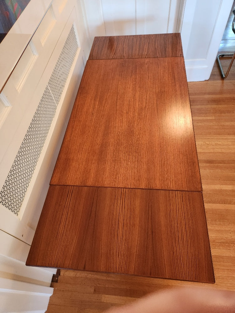 Midcentury modern Perfect size Danish extending teak dining table for a smaller space. At only 48"L, the table can extend up to 79"L with the two hidden leaves. Classic design with continuous grain and tapered legs. Made in Denmark by Farstrup- Cook Street Vintage