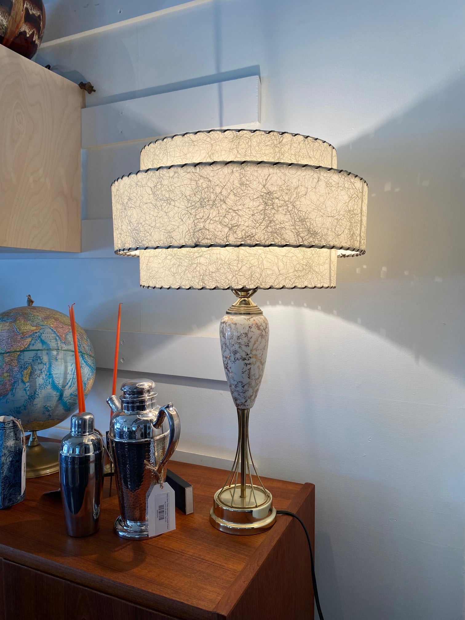 Fun 1950s brass lamp with white and gold porcelain neck. Gorgeous three layer fibregalss shade with whip stitch detail. One small mark on lamp edge but otherwise this lamp is in great condition-Cook Street Vintage
