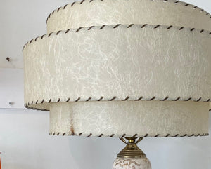 Fun 1950s brass lamp with white and gold porcelain neck. Gorgeous three layer fibregalss shade with whip stitch detail. One small mark on lamp edge but otherwise this lamp is in great condition-Cook Street Vintage