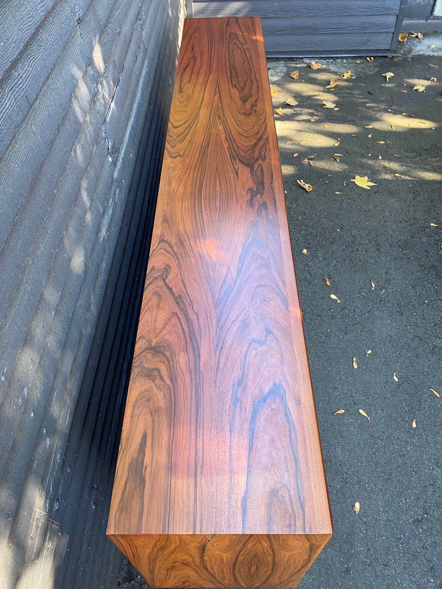 Wonderful 1960s teak sideboard. Incredible grain. Two glass sliding doors, two adjustable height shelves and solid square legs. Perfect for a display case or sideboard- Cook Street Vintage.