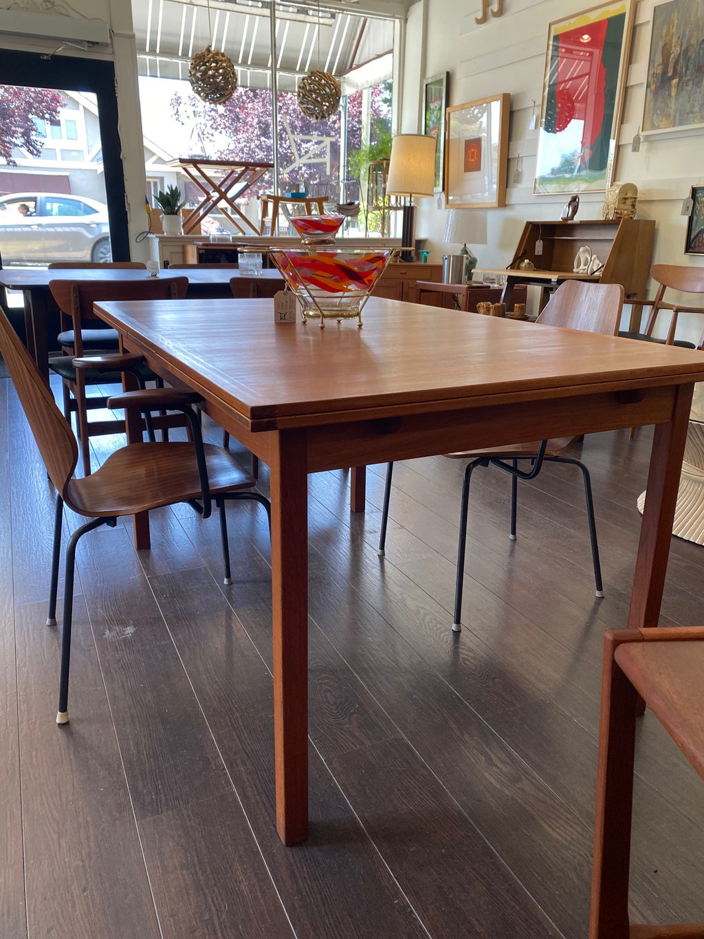MCM eak dining table in store with mid-century and vintage lamps, Don Harvey art and Danish dining chairs-Cook Street Vintage