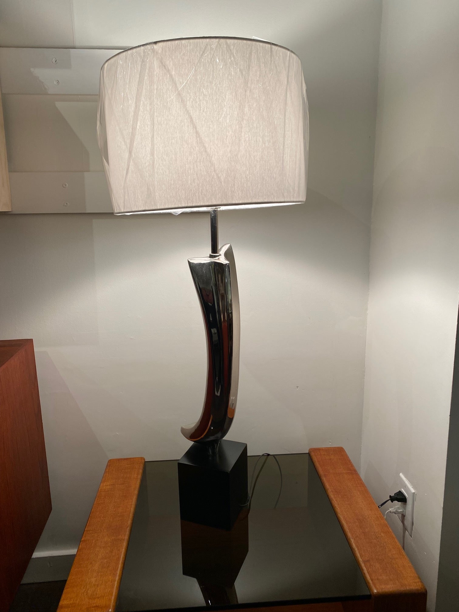 Incredible Laurel Table Lamp by Harold Weiss And Richard Barr. Black base with chrome. Designed by Harold Weiss and Richard Barr Laurel Lamp Company on a smoke glass and teak side table- Cook Street Vintage