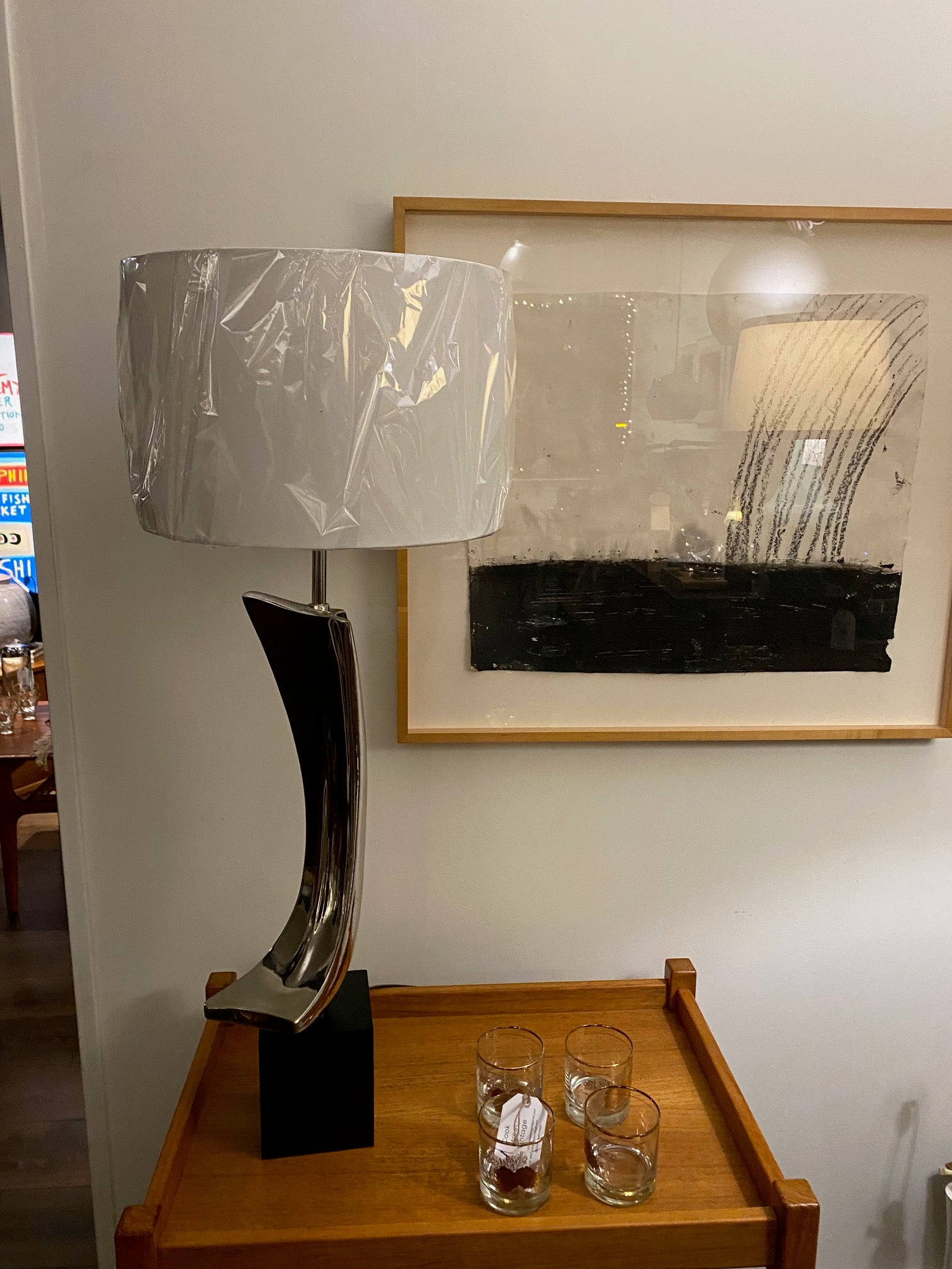 Incredible Laurel Table Lamp by Harold Weiss And Richard Barr. Black base with chrome. Designed by Harold Weiss and Richard Barr Laurel Lamp Company shown on a teak bar cart with a mixed media by Gary Pearson, "Rainbow Effect" on the wall- Cook Street Vintage