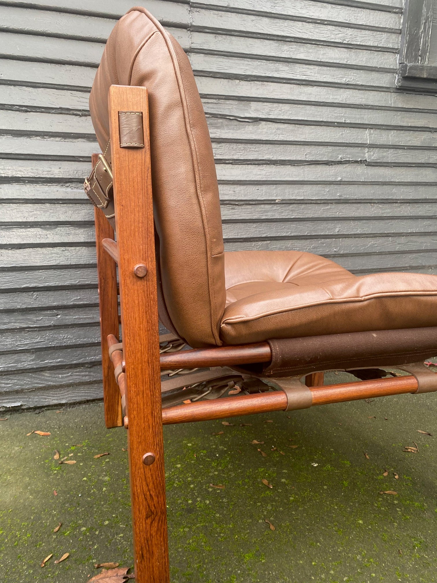 Side view and detail of Arne Norell armless hunting chair in rosewood with original straps and supports. Newly recovered cushions and foam in brown vinyl. Imported by Scanform Colombia. Made in Medellin, Colombia- Cook Street Vintage