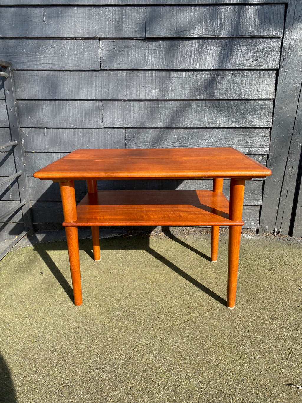 Nice mid-century Scandinavian design teak side table with lower magazine shelf. Elegant tapered legs- Cook Street Vintage