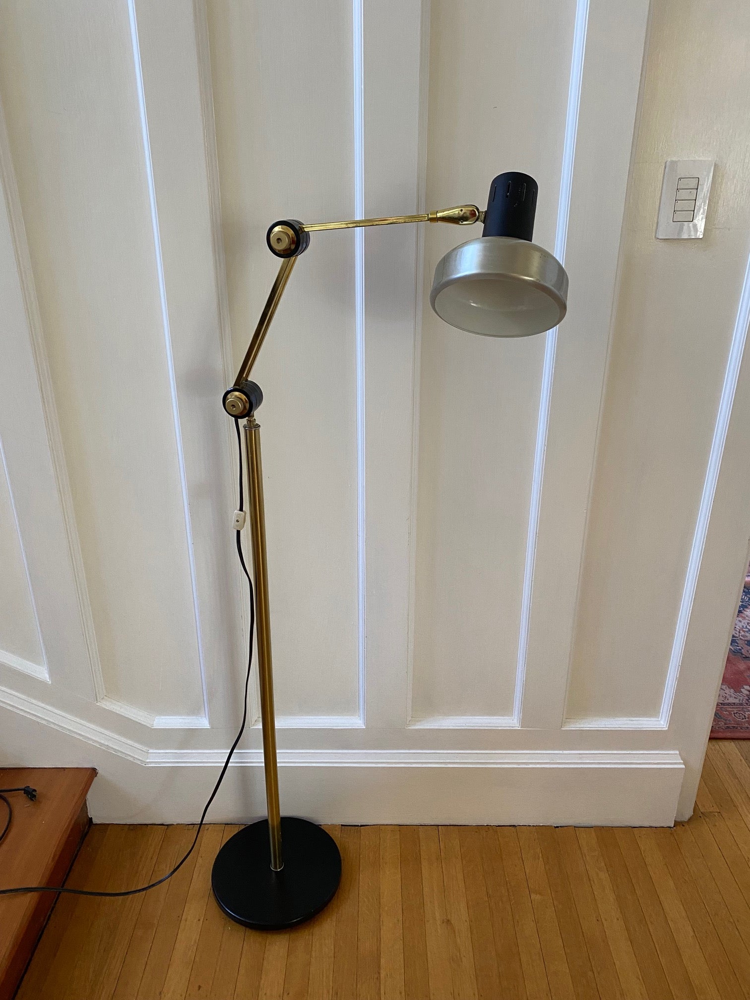 Mid-century brass floor lamp. Retro black knobs at mid-pole adjust height and direction of the lamp. Made by Ward.- Cook Street Vintage