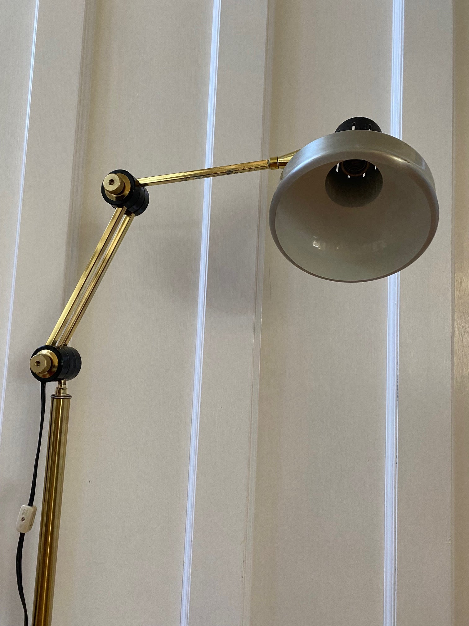 Mid-century brass floor lamp. Retro black knobs at mid-pole adjust height and direction of the lamp. Made by Ward.- Cook Street Vintage