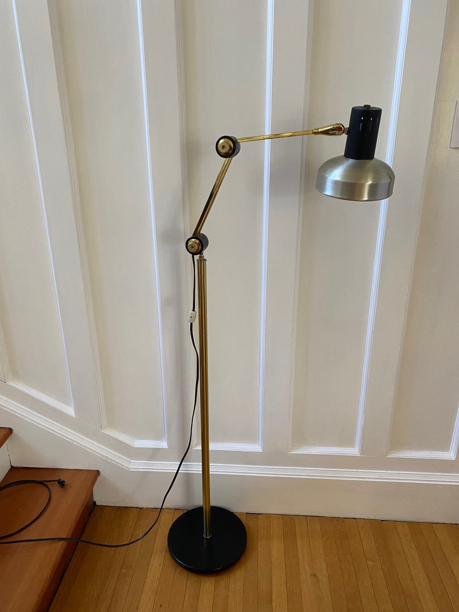 Mid-century brass floor lamp. Retro black knobs at mid-pole adjust height and direction of the lamp. Made by Ward.- Cook Street Vintage