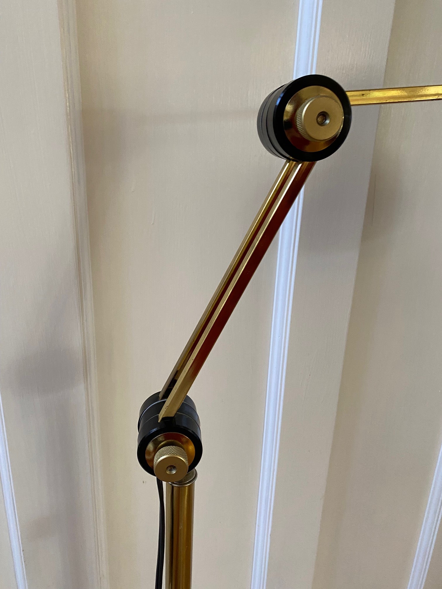 Adjustable knobs of Mid-century brass floor lamp. Retro black knobs at mid-pole adjust height and direction of the lamp. Made by Ward.- Cook Street Vintage