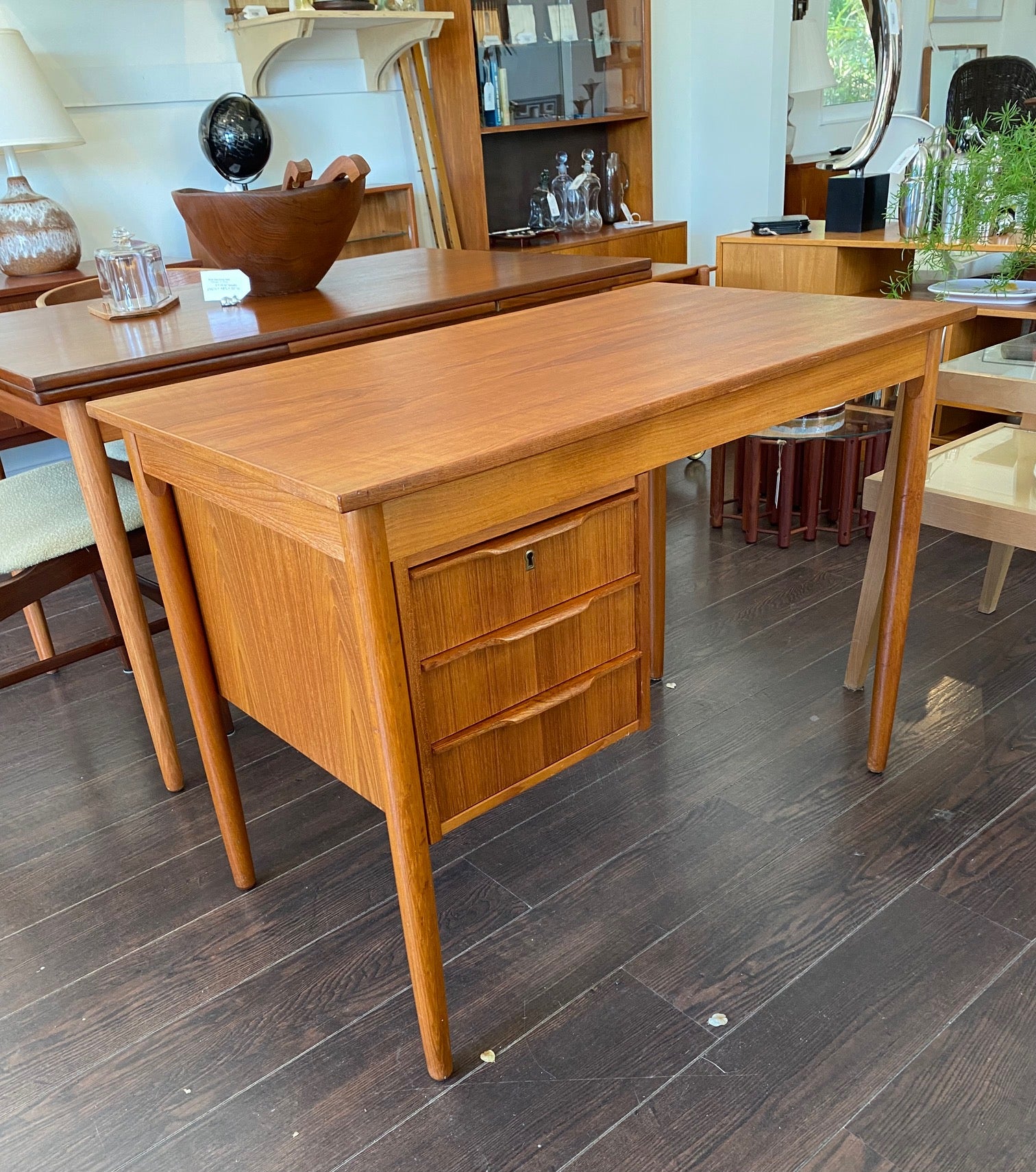 Lovely Mid-century Danish desk in teak and birch manufactured by Ejsing Møbelfabrik. Beautiful at any angle with a finished back. Three dovetailed drawers with sculpted handles. Tapered legs. The perfect fit for small spaces. Key not available. Made in Denmark- Cook Street Vintage.