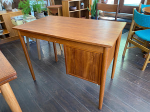 Lovely MCM Danish desk in teak and birch manufactured by Ejsing Møbelfabrik. Beautiful at any angle with a finished back. Three dovetailed drawers with sculpted handles. Tapered legs. The perfect fit for small spaces. Key not available. Made in Denmark- Cook Street Vintage.