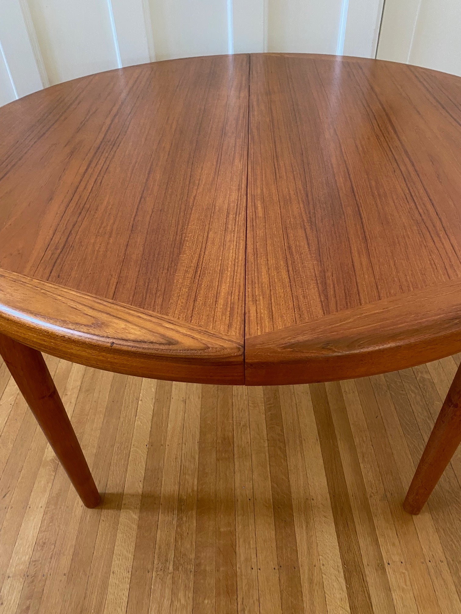 Close up of grain on Gorgeous Mid-century honey teak round dining table. Smaller profile than our other round dining tables, this beauty has an elegant staved edge of solid teak- Cook Street Vintage