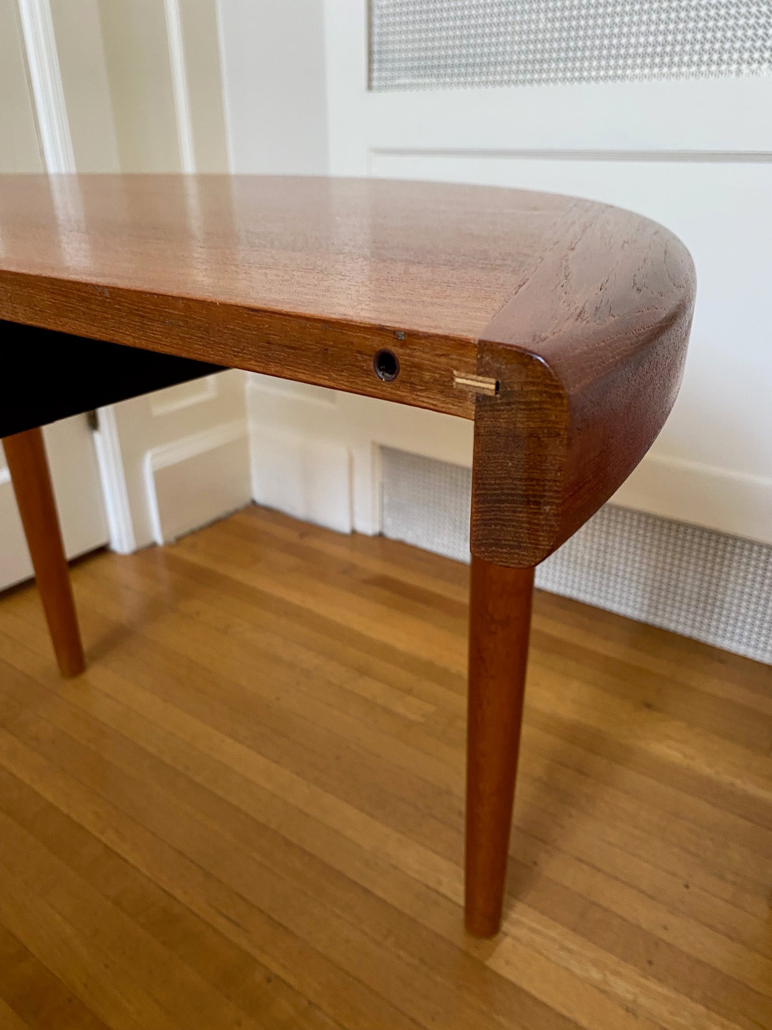 detail of inside of table. Gorgeous Mid-century honey teak round dining table. Smaller profile than our other round dining tables, this beauty has an elegant staved edge of solid teak- Cook Street Vintage