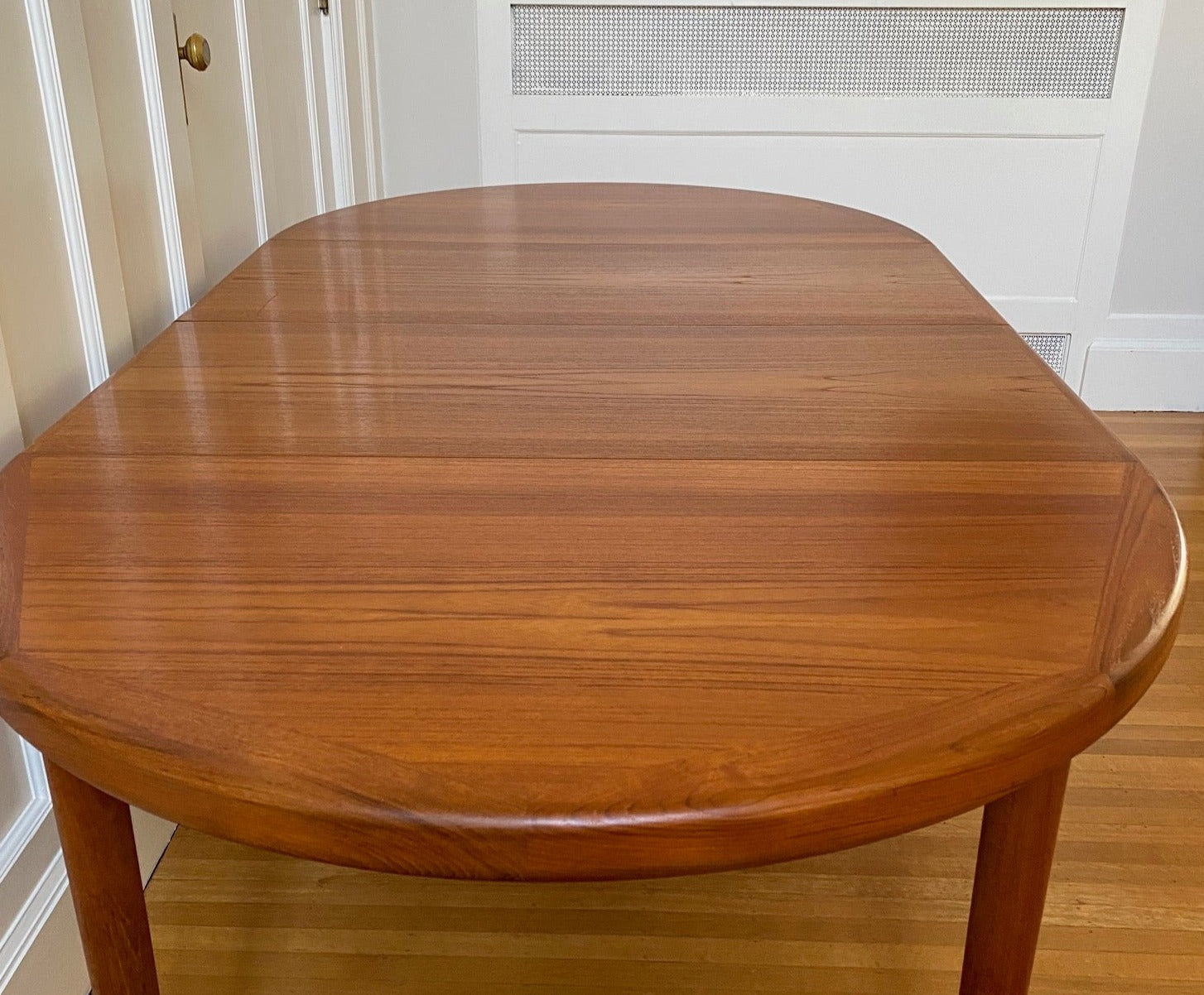 Grain wiht two leaves in. Gorgeous Mid-century honey teak round dining table. Smaller profile than our other round dining tables, this beauty has an elegant staved edge of solid teak- Cook Street Vintage