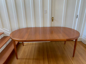 two leaves in Gorgeous Mid-century honey teak round dining table. Smaller profile than our other round dining tables, this beauty has an elegant staved edge of solid teak- Cook Street Vintage