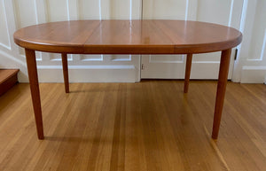 One leaf in Gorgeous Mid-century honey teak round dining table. Smaller profile than our other round dining tables, this beauty has an elegant staved edge of solid teak- Cook Street Vintage