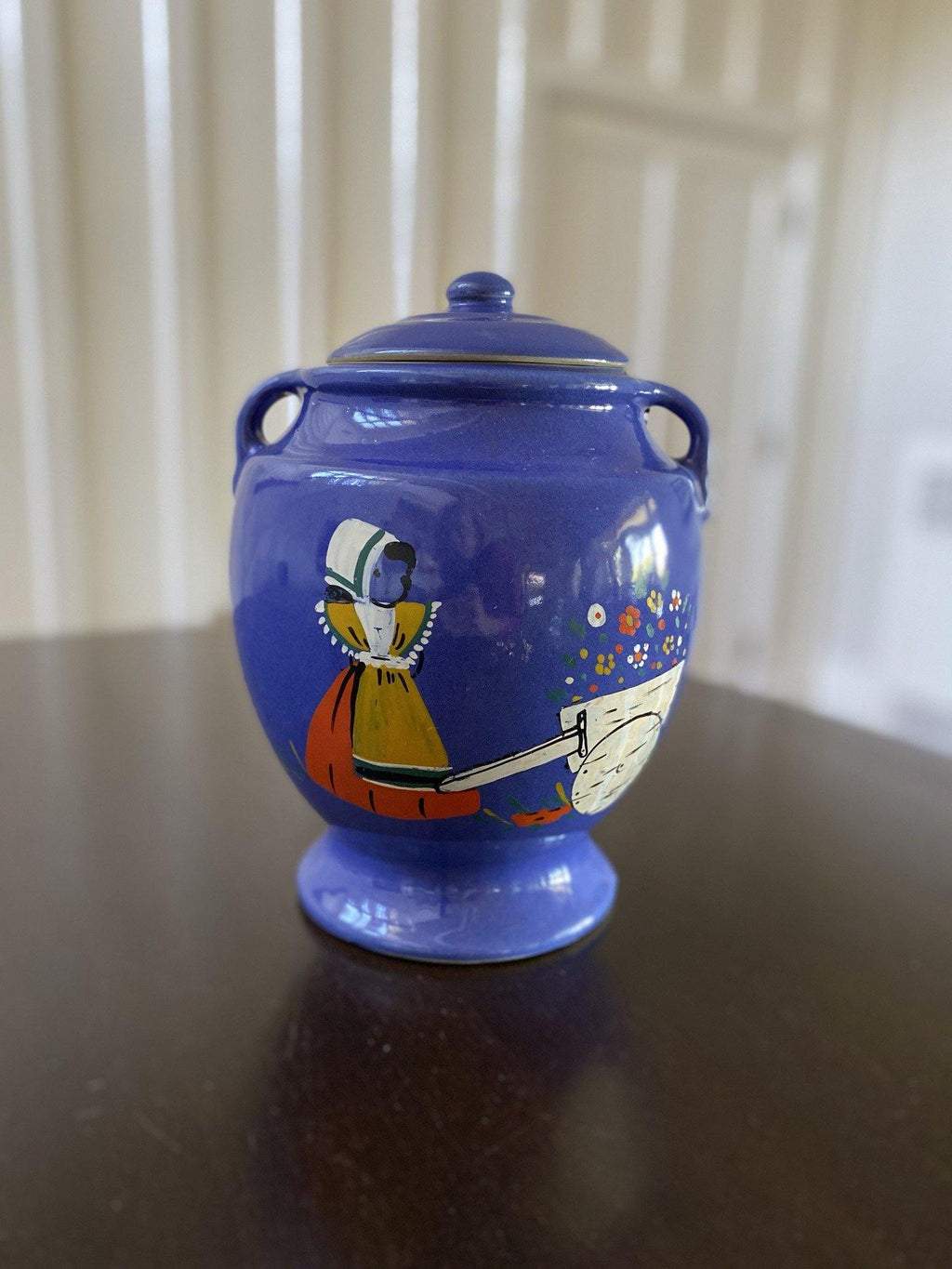 Blue biscuit jar with illustration of girl and wagon of flowers -Cook Street Vintage