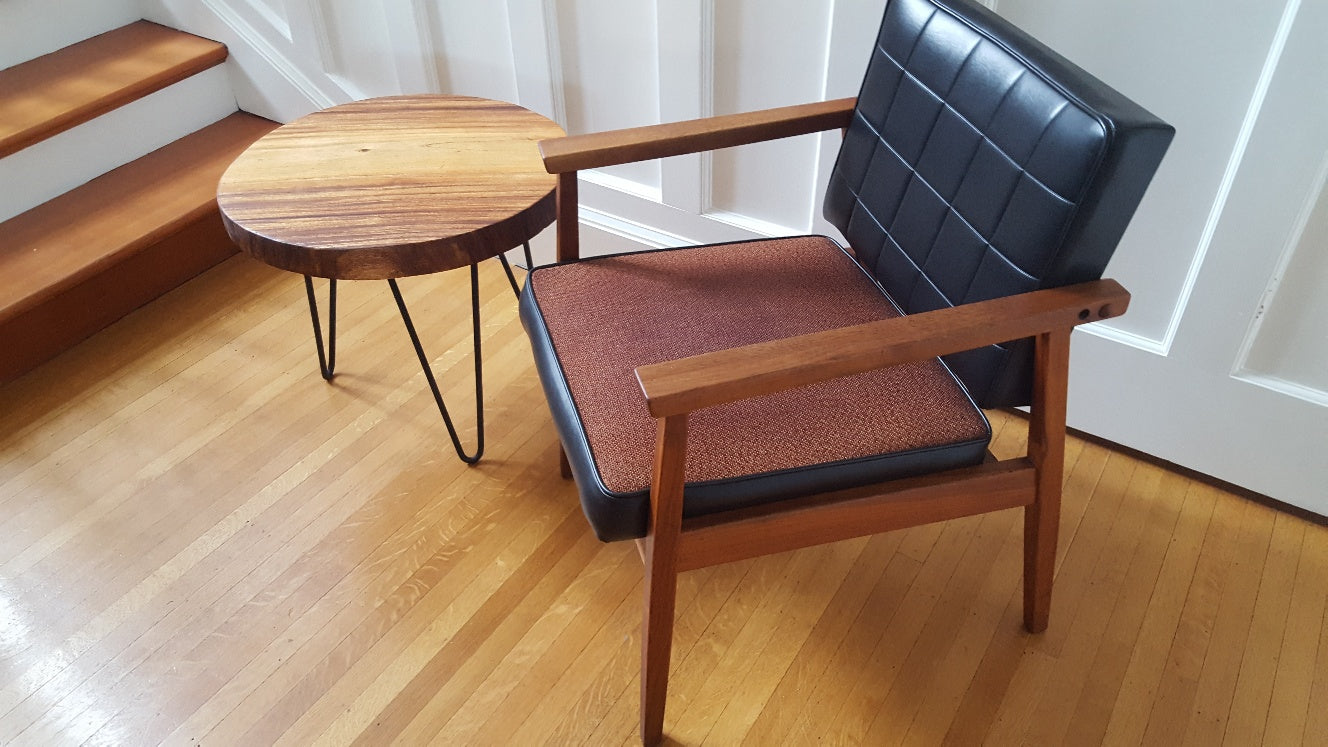 Side view of teak arm chair with black vinyl and brown uphostery with teak side table with hairpin legs- Cook Street Vintage