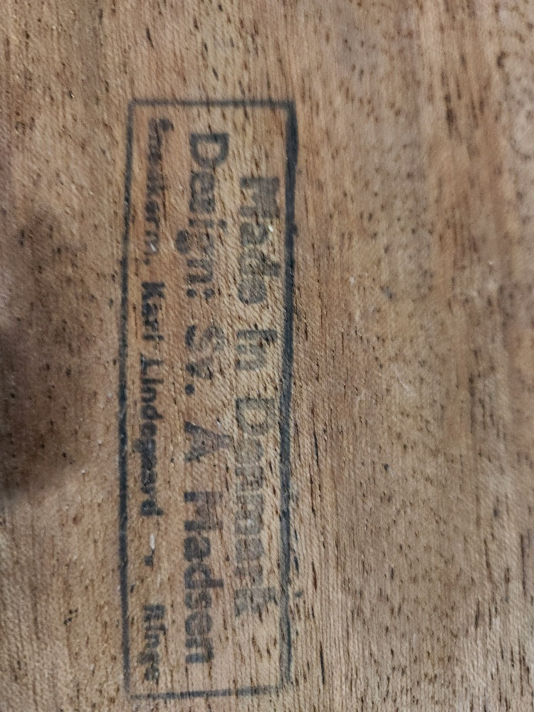 Stamp identifying mark at bottom of Beautiful MCM teak coffee table. Designed by Svend madsen for Karl Lindegaard. Made in Denmark -Cook Street Vintage