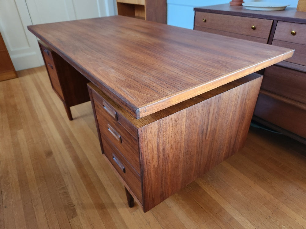 Gorgeous teak desk with floating top. Classic design with beautiful wood grain front and back. Two pull out writing tables, filing drawer and ample storage in drawers. Freshly restored. Made in Canada by RS Associates- Cook Street Vintage