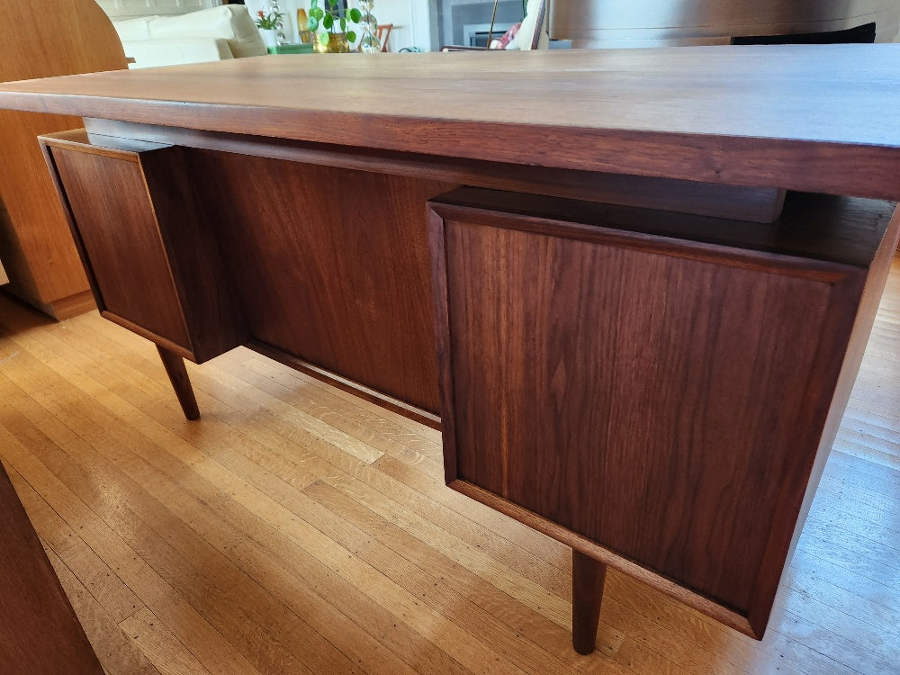 Back side view of teak desk with floating top. Classic design with beautiful wood grain front and back. Two pull out writing tables, filing drawer and ample storage in drawers. Freshly restored. Made in Canada by RS Associates- Cook Street Vintage