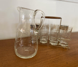Vintage glass pitcher iwth stylized embossed flowers with 8 cocktail glasses in background- Cook Street Vintage