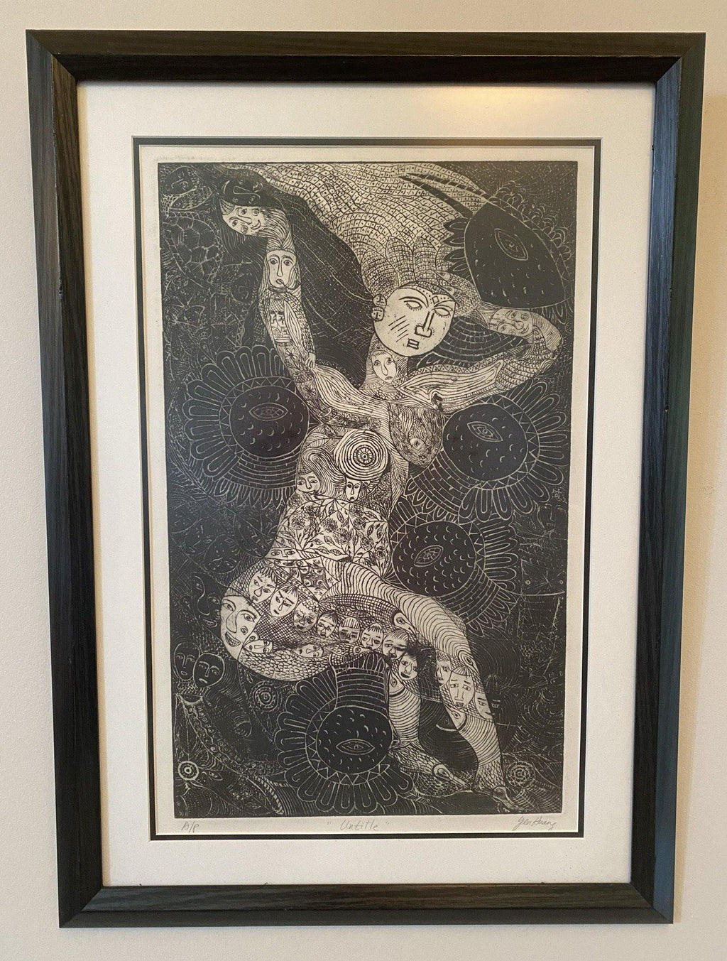 Full view of black and white image of a tattoed figure with eye motifs in background- Cook Street Vintage