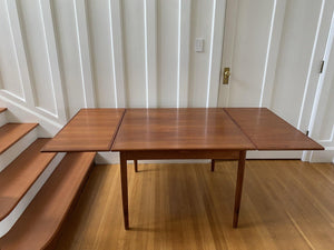 Front view of fully extended Danish Mid-Century teak dining table by Henning Kjaernulf with two hidden draw leaves- Cook Street Vintage