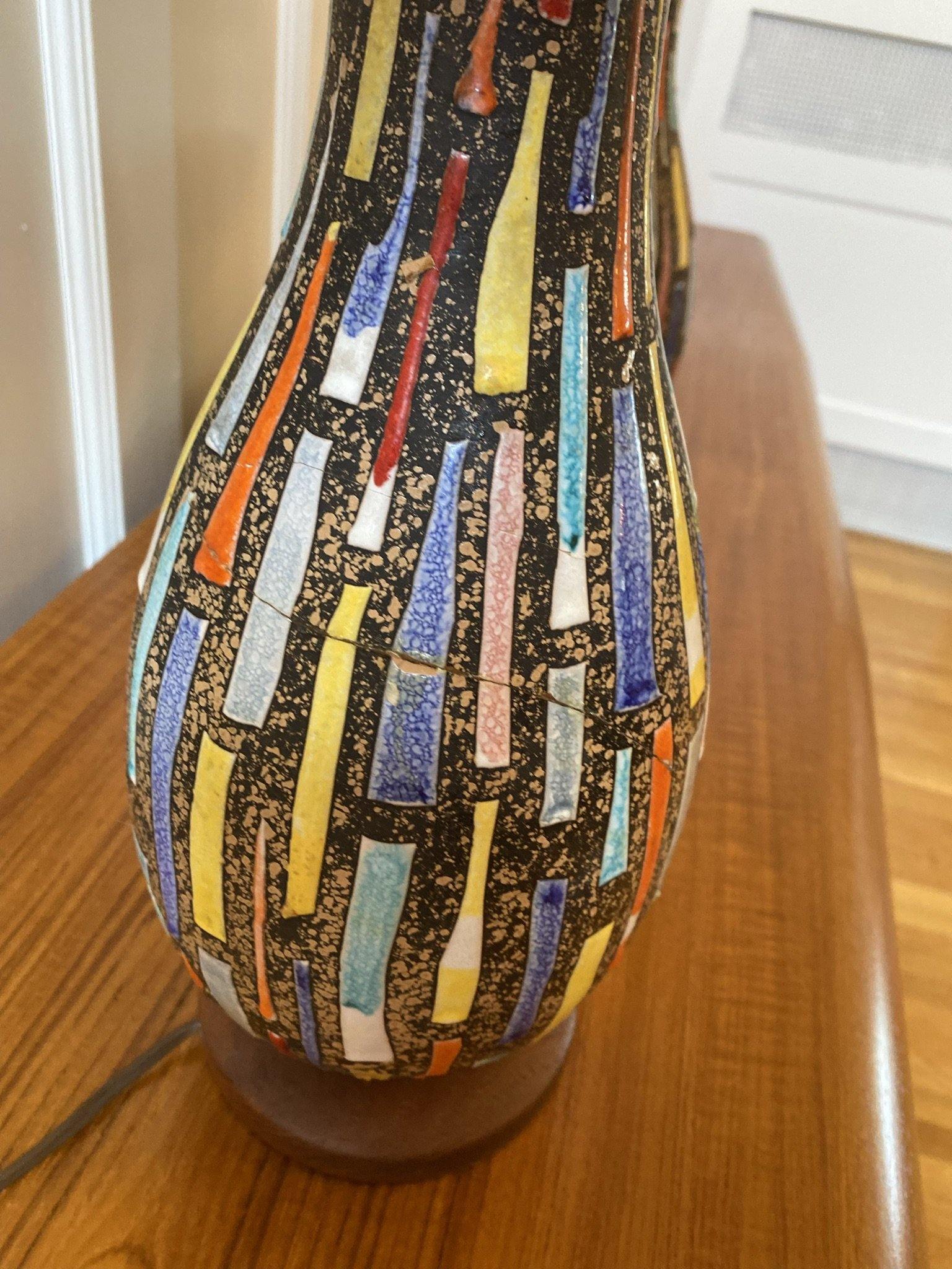Close up of damage on decorative MCM table lamps with blue, orange and yellow tile like motif with charcoal black background- Cook Street Vintage
