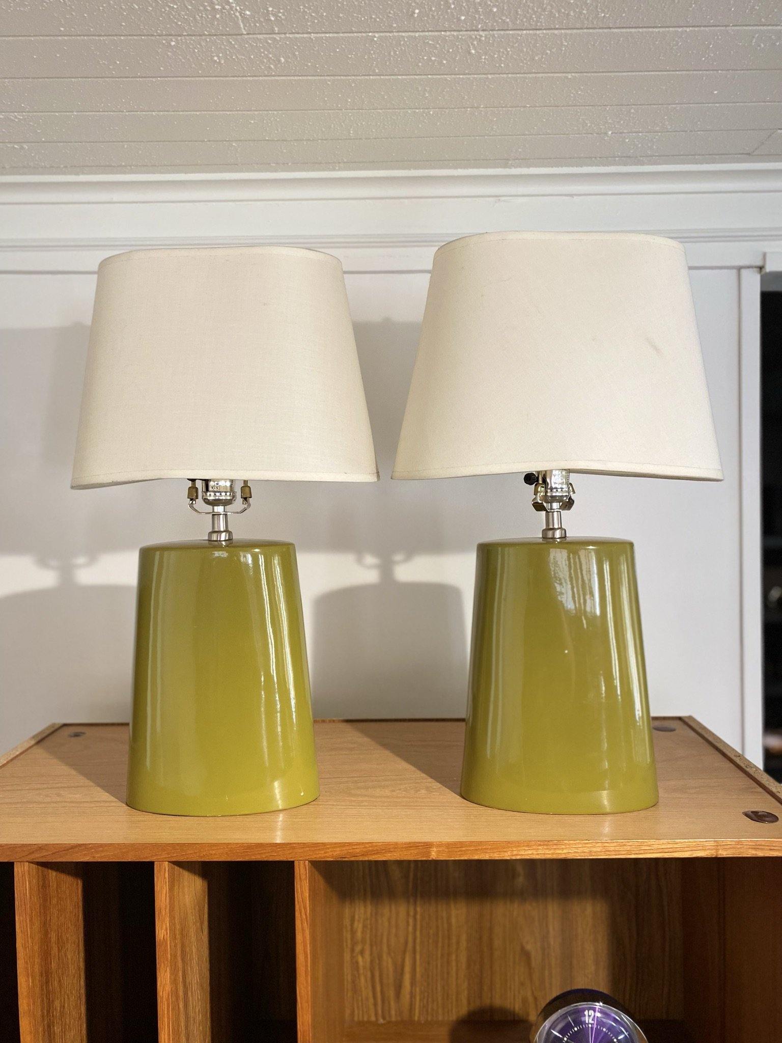Two olive green lamps with white shades on top of teak table- Cook Street Vintage
