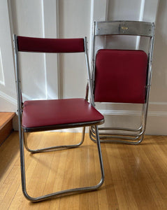 Chrome and red vinyl folding chair with two chairs folded behind it- Cook Street Vintage