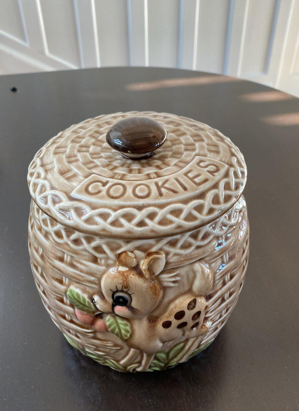 Front view of basket weave cookie jar with adorable deer eating cherries motif- Cook Street Vintage