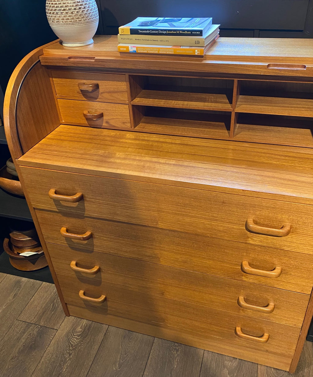 Gorgeous Scandinavian design mid-century roll-top teak desk. Top rolls up to reveal cubby holes, two small drawers and a removable shelf. Top is a retractable desktop. Lower cabinet includes four large drawers- Cook Street Vintage