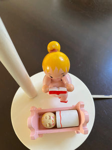 Birds eye view of mother reading story to baby in crib on base of Irmi midcentury lamp- Cook Street Vintage