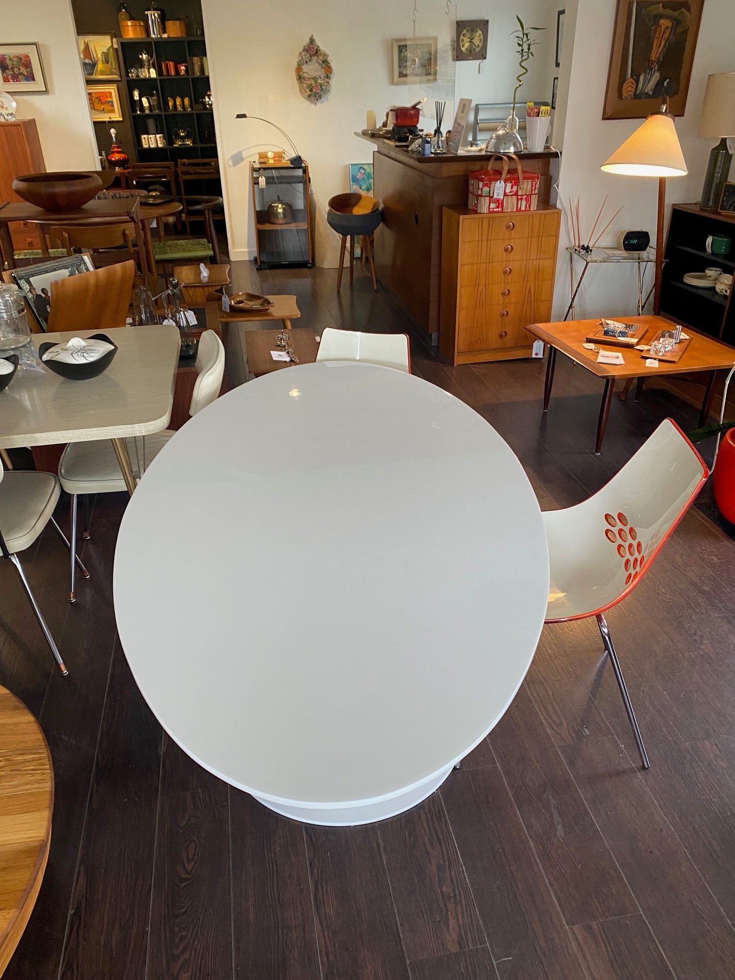 Stunning white laminate tulip table. Gorgeous beveled edge and metal base. In nice overall condition with some scratching on table surface. Shown with orange Calligaris "Jam" dining chairs- Cook Street Vintage