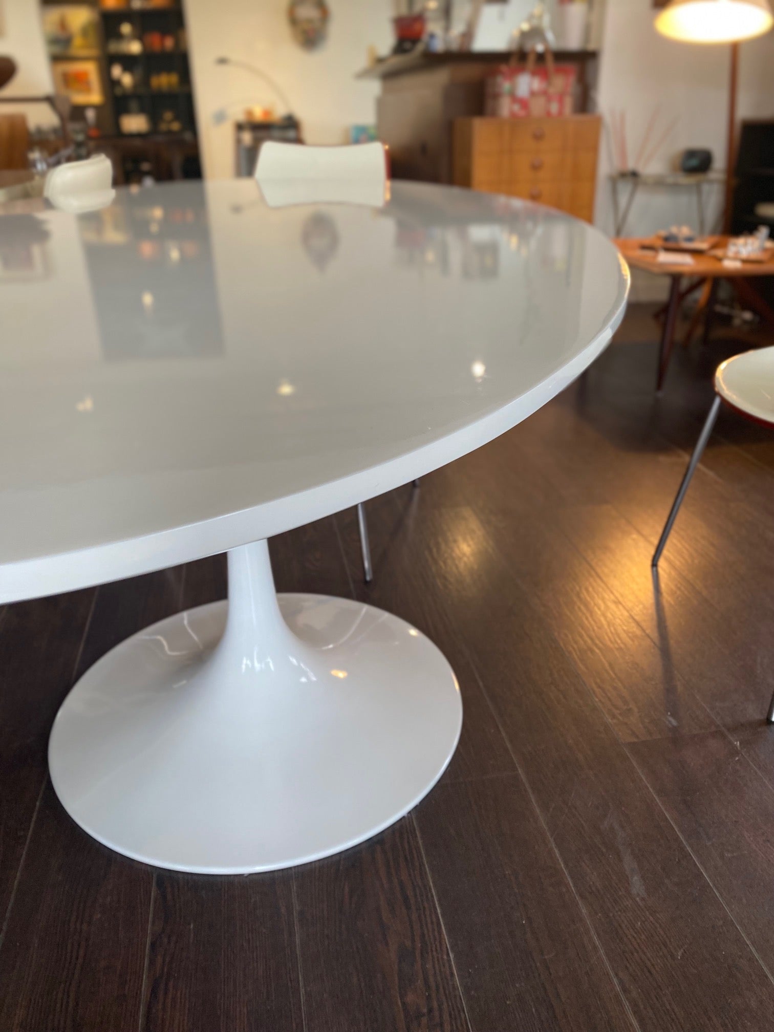 Stunning white laminate tulip table. Gorgeous beveled edge and metal base. In nice overall condition with some scratching on table surface. Shown with orange Calligaris "Jam" dining chairs- Cook Street Vintage