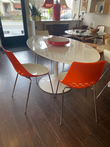 Stunning white laminate tulip table. Gorgeous beveled edge and metal base. In nice overall condition with some scratching on table surface. Shown with orange Calligaris "Jam" dining chairs- Cook Street Vintage