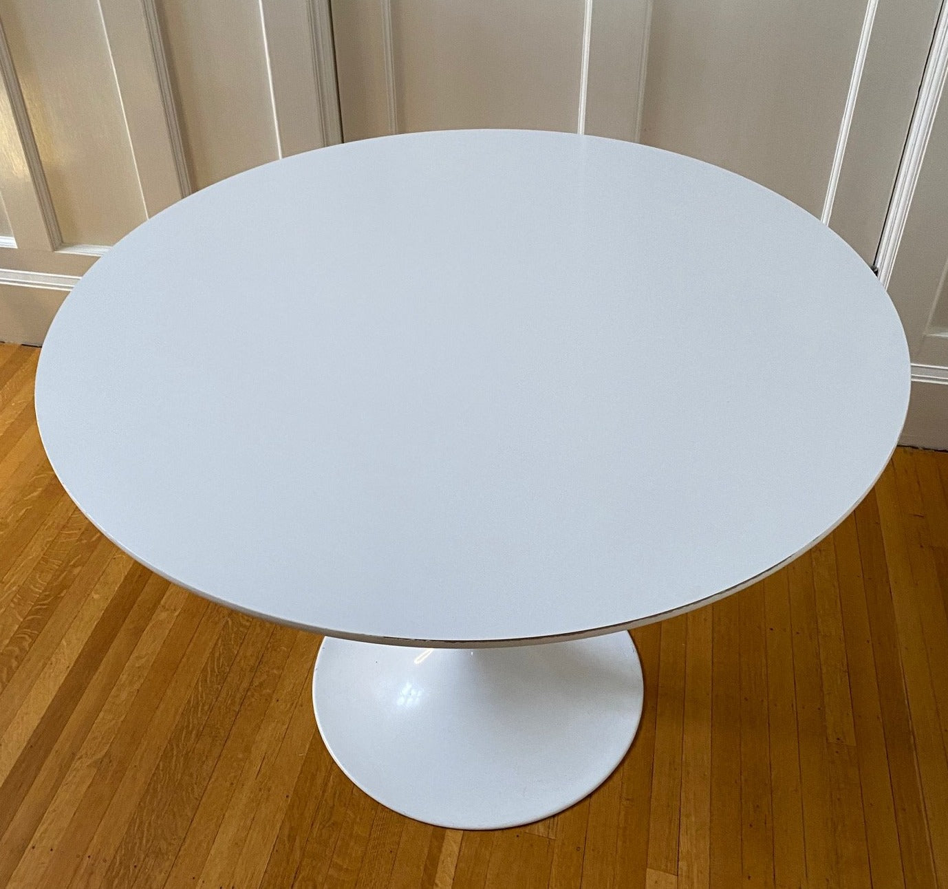 Vintage Tulip Style table. White coated laminate circular top with a finished steel pedestal stem. 