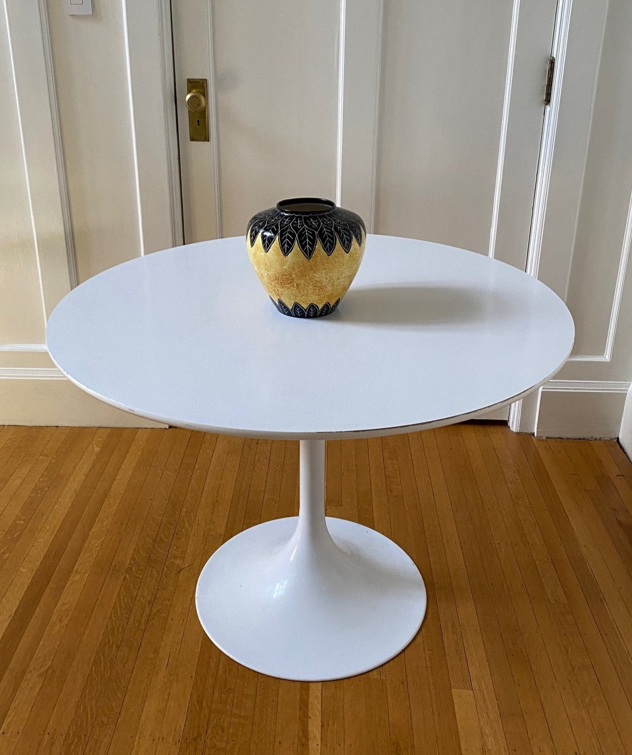 Vintage Tulip Style table. White coated laminate circular top with a finished steel pedestal stem. 