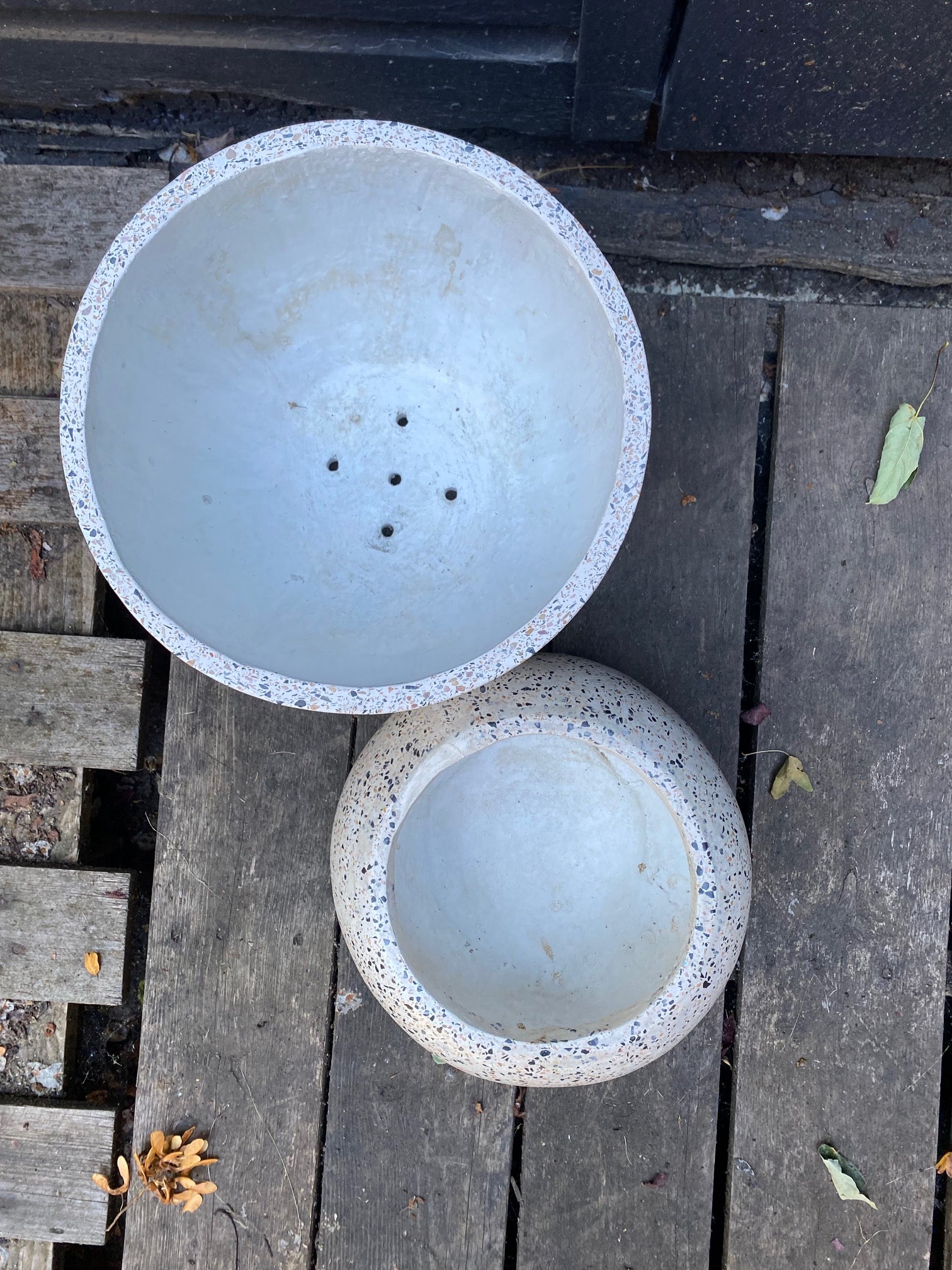 Top view of large oval terrazzo planter with drain holes and small round terrazzo planter with no drain holes- Cook Street Vintage